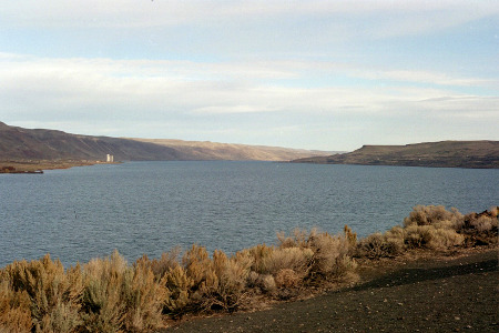 [There is some short sagebrush in the foreground, but the entire background is high hillsides and the curve of the river makes it appear one is looking at a lake rather than a river.]